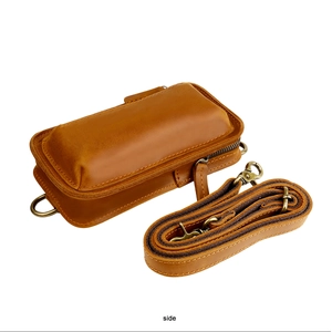 Side view of retro brown leather bag with adjustable strap and vintage bronze hardware