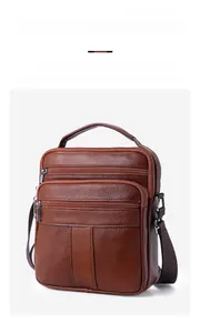 Detailed view of brown leather messenger bag featuring multiple zipper compartments and handle