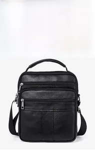 Detailed front view of black pebbled leather crossbody bag with dual zipper pockets