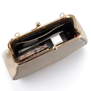 Sac baguette beige en cuir grainé avec fermoir doré montrant un intérieur bien organisé