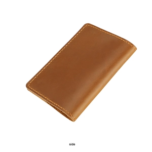 Detailed side view of the brown leather passport holder with neat stitching and texture
