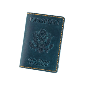 Detailed view of leather US passport cover with orange stitching and embossed emblem