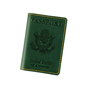 Detail of dark green leather passport holder with yellow stitching and US emblem