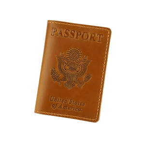 Close-up of brown leather US passport cover with embossed Great Seal and yellow stitching