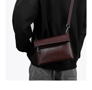 Détail d'un sac bandoulière en cuir marron avec rabat enveloppe et boucle en argent rétro
