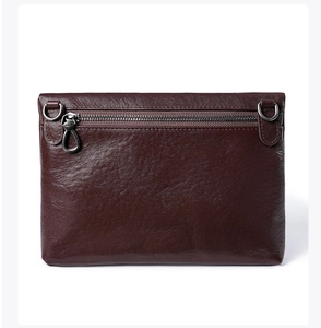 Détail de sac bandoulière en cuir marron avec fermeture éclair arrière et anneaux en métal