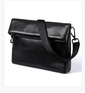 Détail d'un sac bandoulière en cuir tanné végétal noir avec texture brillante