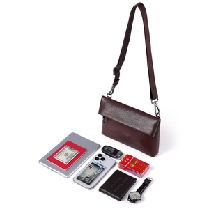 Sac bandoulière homme en cuir marron foncé avec bandoulière réglable et objets du quotidien