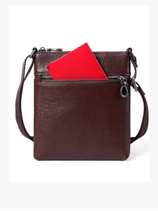Close-up of dark brown leather crossbody bag with front zipper pocket and passport