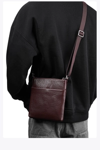 Rear view of deep brown textured leather crossbody bag worn by a male model