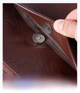 Macro detail of dark brown pebble leather bag featuring a magnetic snap closure with engraving