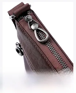 Detail of premium silver metal zipper and lychee pattern leather texture on men's crossbody bag