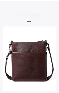 Vertical dark brown leather crossbody bag with front pocket and textured finish