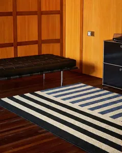 Nordic absorbent door mat with dark blue geometric stripes on dark wood floor