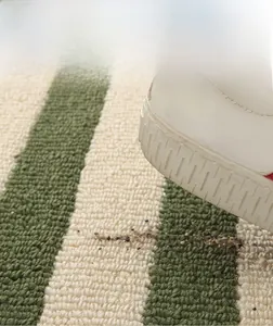 Detailed view of striped absorbent bath mat with non-slip texture for door entry