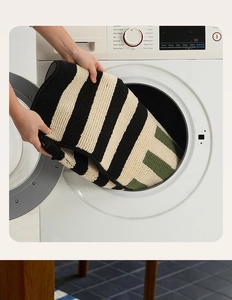 Detail of striped absorbent mat being put into a washing machine for easy cleaning