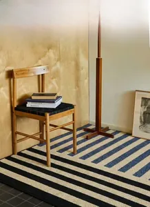 Detail of Nordic striped rug in blue and beige tones within a modern living room setting