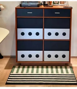 Detail of Nordic striped absorbent bath mat placed before a six-drawer wooden cabinet