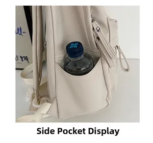 Detail view of the cream white backpack side pocket holding a black water bottle