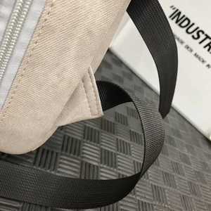 Macro detail of high-density canvas backpack with reinforced nylon shoulder strap stitching