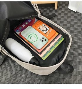 Internal view of beige backpack showing large capacity for laptop, books and water bottle
