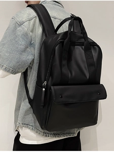 Side view of black matte leather backpack with dual top handles and double buckle front pocket