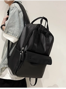 Side view of man wearing minimalist black leather backpack with large front pocket