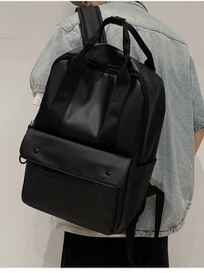 Side view of a black minimalist leather laptop backpack worn by a model for travel