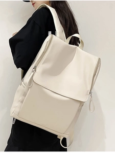 Detailed side view of a minimalist cream-colored backpack with premium matte finish and flap