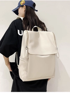 Side view of large off-white backpack on model showing modern design and large capacity