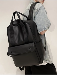 Detailed view of black minimalist PU leather backpack with wide straps on a model