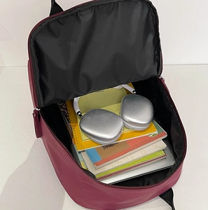 Internal view of a spacious burgundy backpack holding a laptop and textbooks