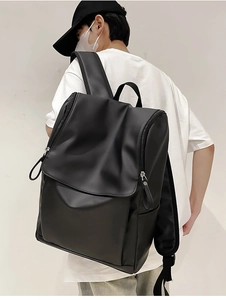 Close-up of minimalist black backpack made of smooth waterproof material on model