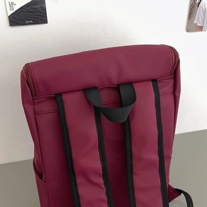 Detail of dark burgundy backpack back with thick nylon straps and premium matte finish