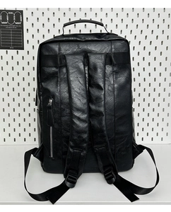Detail of black PU leather backpack with luggage strap and padded shoulder straps
