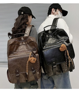 Detailed close-up of brown and black PU leather backpacks with vintage buckle pockets