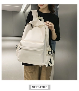Detail of minimalist cream backpack showing adjustable side buckles and breathable mesh pockets