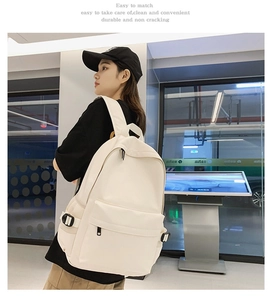 Side view of cream white large capacity school backpack on a model in urban setting
