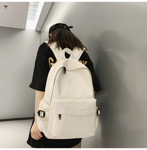 Detail of cream white canvas backpack with side mesh pocket and black adjustable buckle