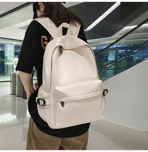 Detail of minimalist beige soft leather backpack with functional front zipper pocket