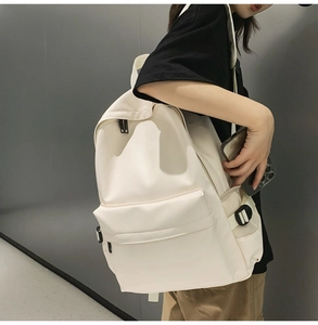 Detail of cream white soft leather backpack featuring functional side mesh pocket for phone