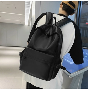 Side view of a student carrying a minimalist black soft leather backpack for daily commute