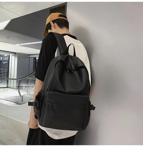 Minimalist black waterproof backpack on male model in modern urban setting