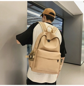 Rear view of minimalist soft leather khaki backpack worn by model in a modern room