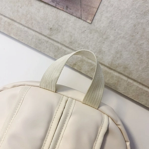Detailed top view of off-white backpack handle and neat stitching on smooth soft leather