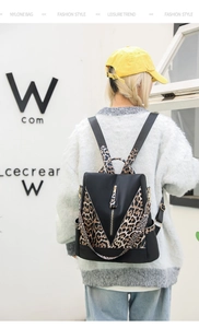 Détail des bretelles à imprimé léopard et du tissu en nylon sur un sac à dos noir