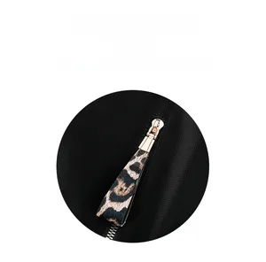 Détail de la fermeture éclair en cuir léopard et métal doré sur sac à dos