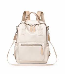 Vorderansicht eines cremefarbenen Nylon-Rucksacks mit Metallreißverschlüssen und Seitentaschen