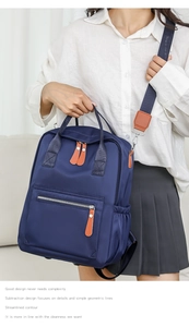 Detailansicht eines blauen Nylonrucksacks mit robusten braunen Leder-Reißverschlussgriffen