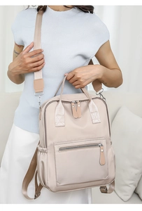Detail eines wasserfesten beigen Nylon-Rucksacks mit verstellbaren Riemen und Zippern